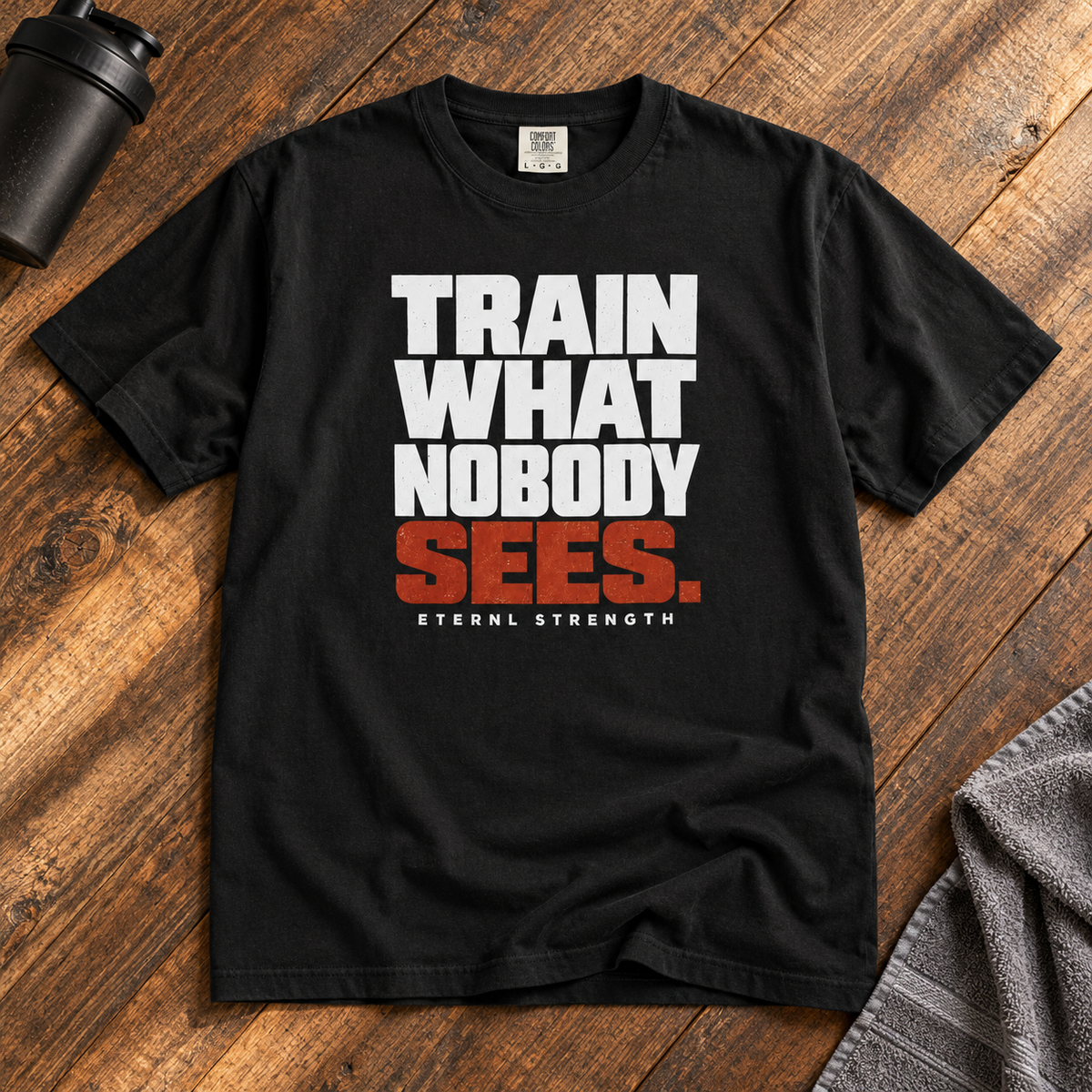 TRAIN WHAT NOBODY SEES tee in Black — smaller front print on rustic wood
