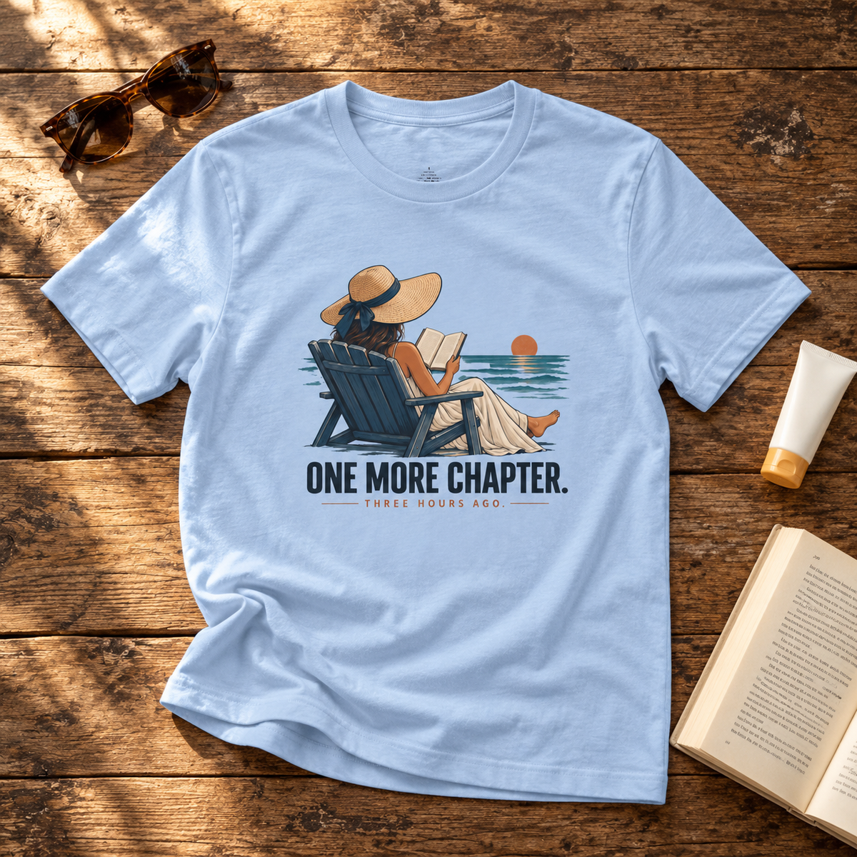 One More Chapter Bella+Canvas 3001 tee in Baby Blue — front reading illustration on rustic wood