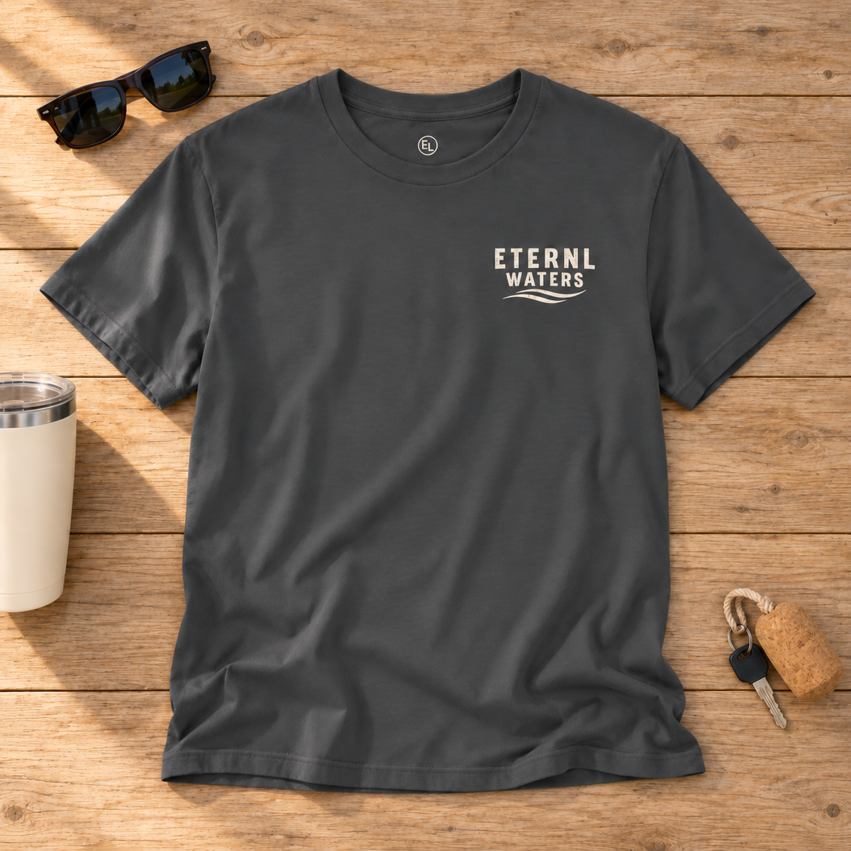 GOOD DAYS asphalt tee front with ETERNL WATERS chest mark on rustic wood